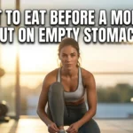 Realistic YouTube thumbnail featuring a banana, oats, toast, honey, and water beside gym gear, with bold text “What to Eat Before a Morning Workout on Empty Stomach 2026” in a bright, high-contrast fitness nutrition design.